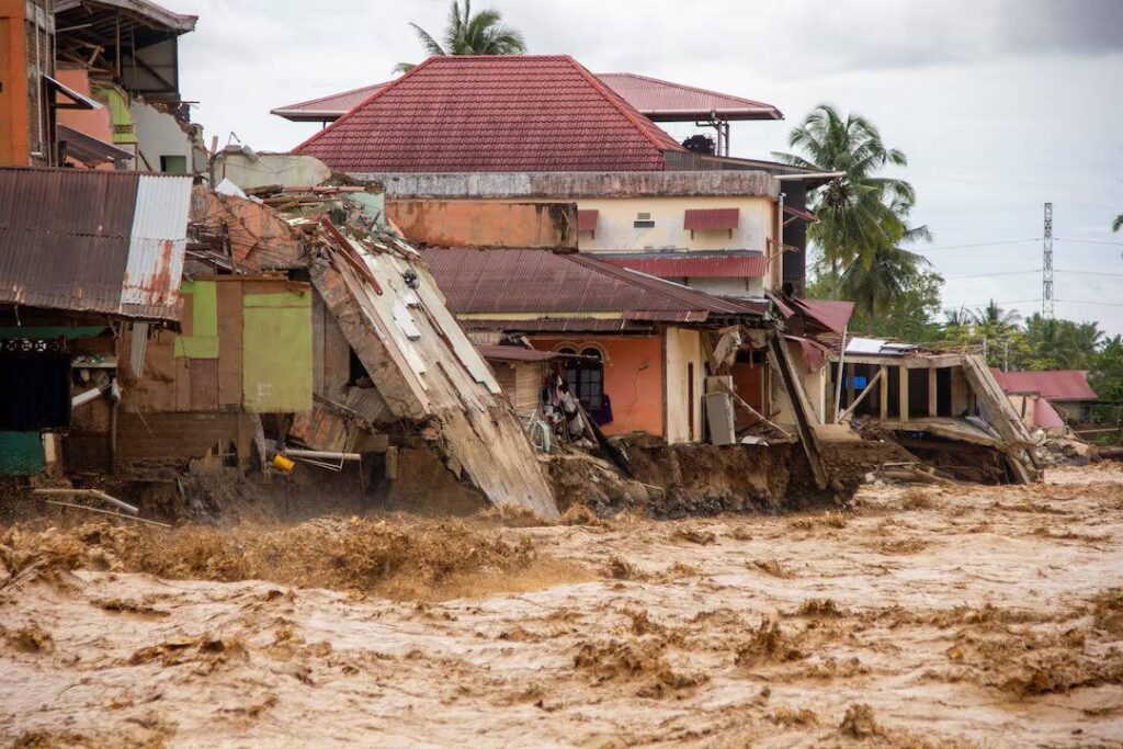 Rumah-rumah yang rusak akibat banjir bandang, di dekat tepi sungai di Padang, Sumatera Barat